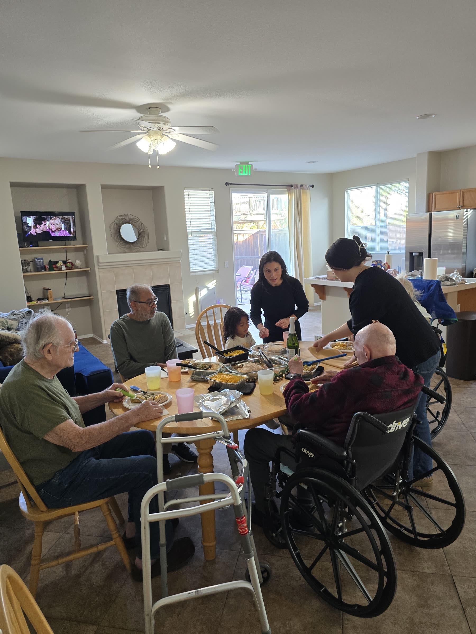 A community gathering around the dining table at Everlast Assisted Living