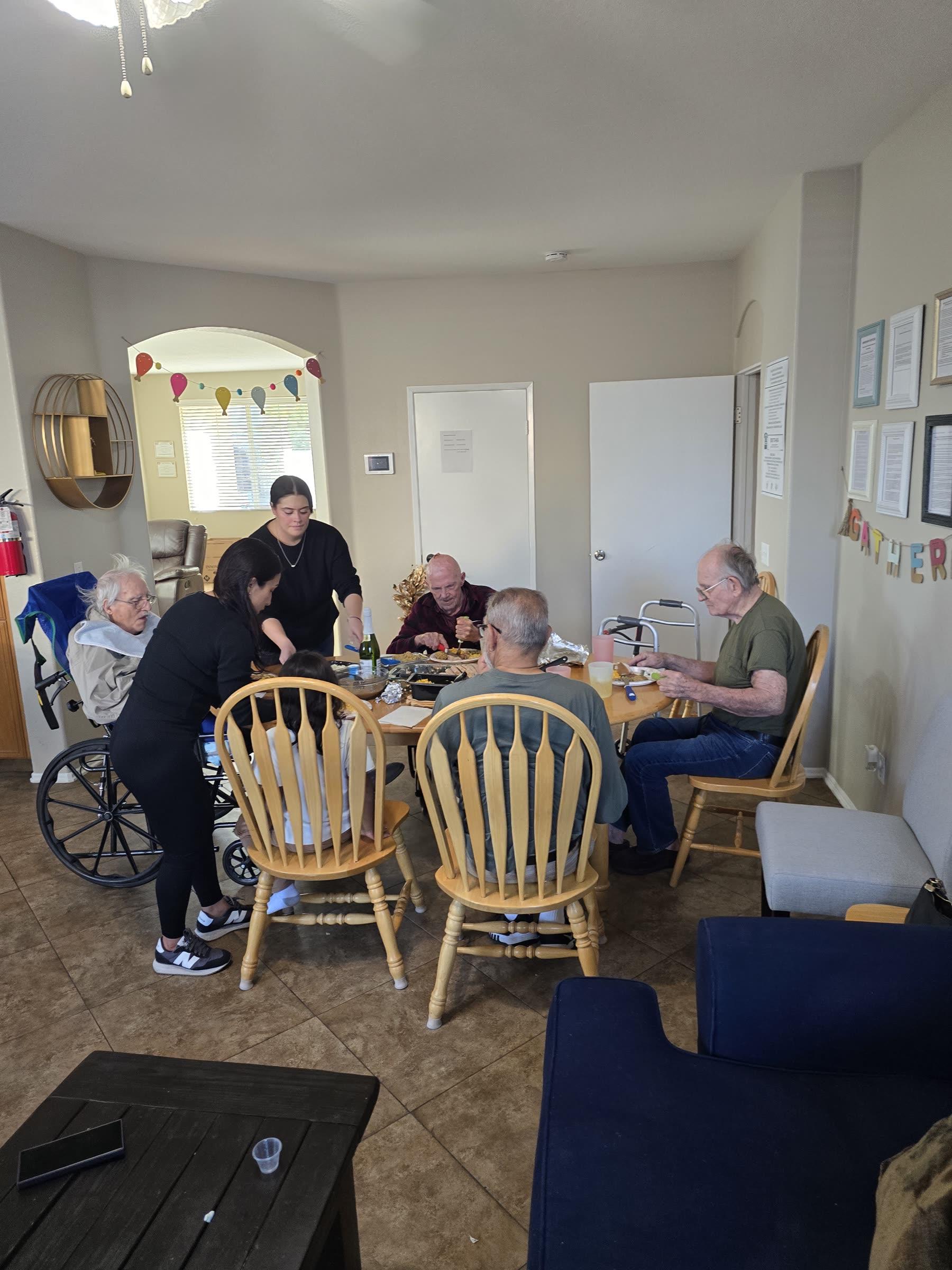 Residents and caregivers sharing a holiday meal together at Everlast Assisted Living